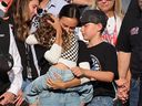 Samantha Busch, the wife of late NASCAR star Kyle Busch, holds their daughter Lennix next to son Brexton during a remembrance ceremony on Sunday, prior to the NASCAR Cup Series Coca-Cola 600.