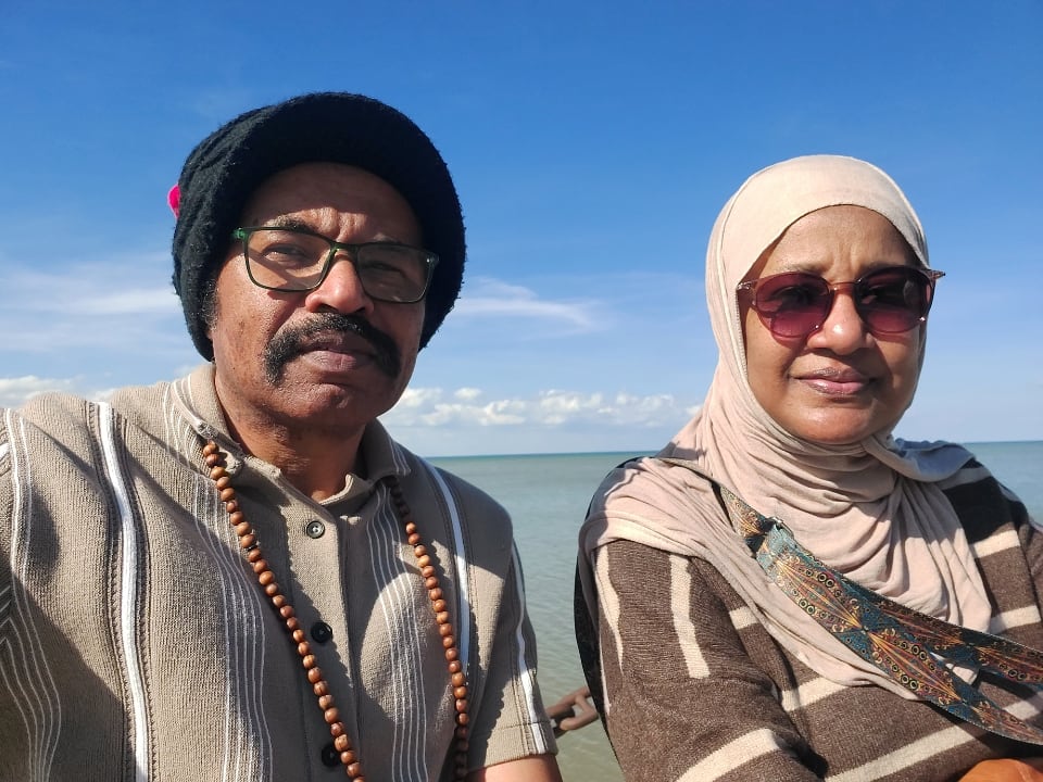 A man and a woman in front of a body of water.