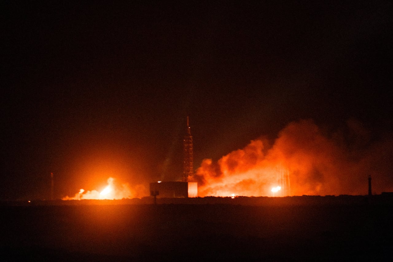 A rocket is in flames on a launchpad.