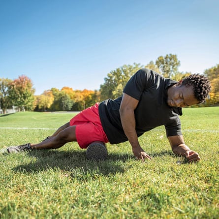 A person using an OTPT Axis Foam Roller