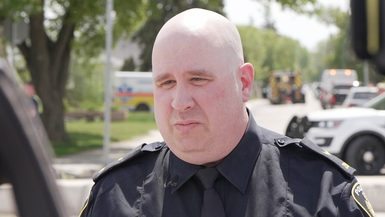 A bald man wearing a dark blue police uniform.