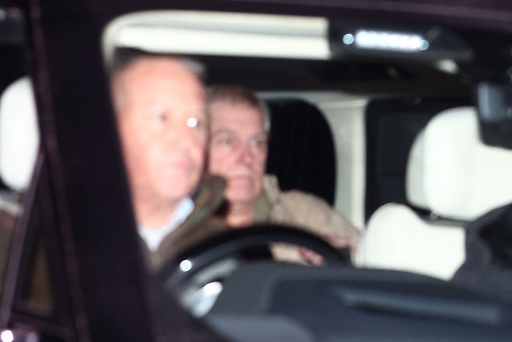 A driver and a rear-seat passenger sit in a car.