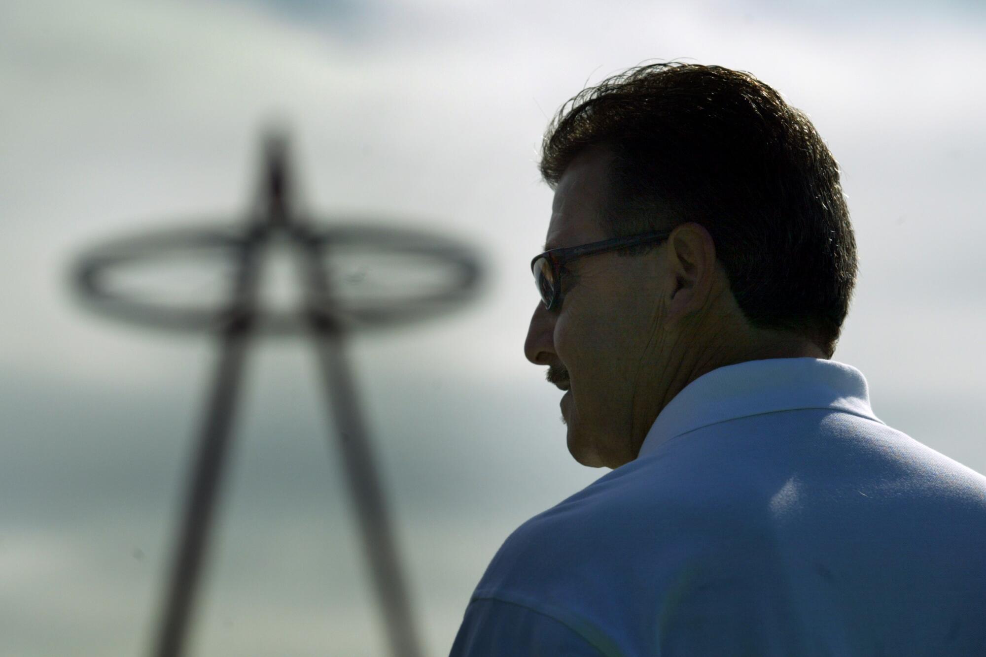 Angels owner Arte Moreno signs autographs and poses with fans with the Angel Stadium halo in the background.