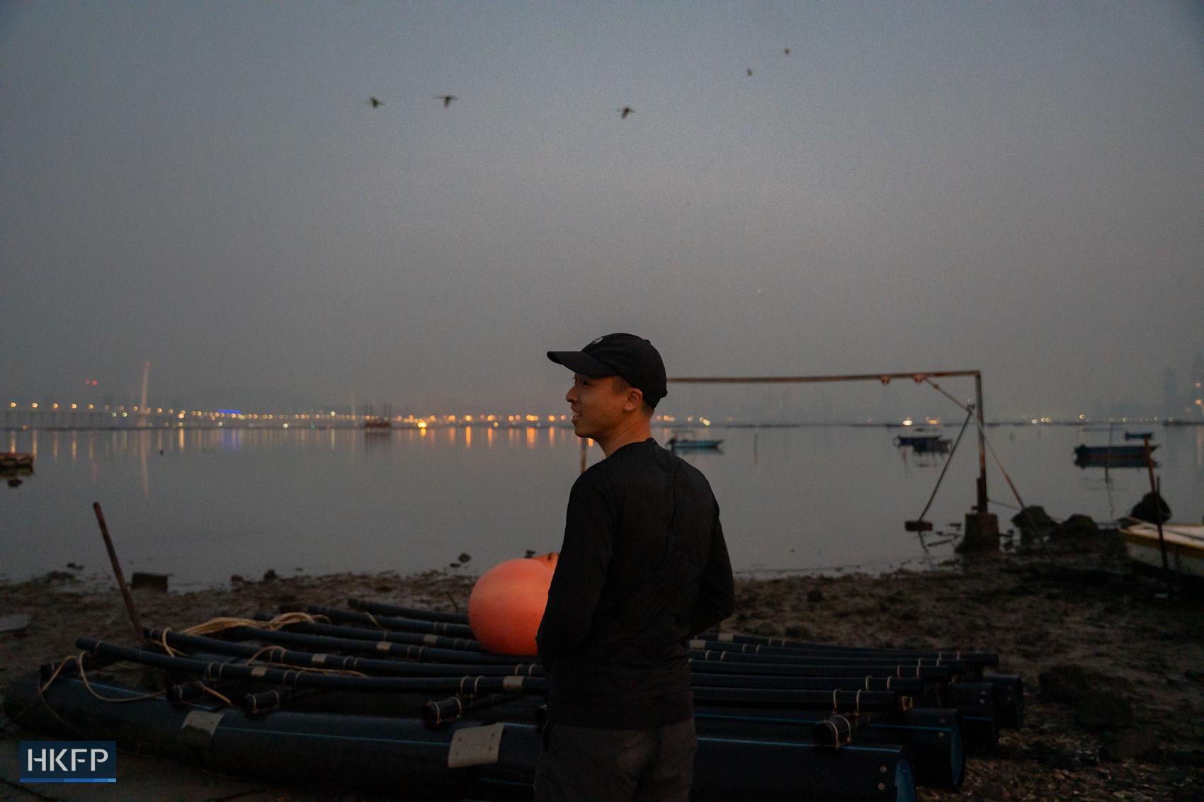 Fung Hon-shing at a remote shore in Yuen Long in the early morning of March 25, 2026, to photograph migratory birds. Photo: Kyle Lam/HKFP.