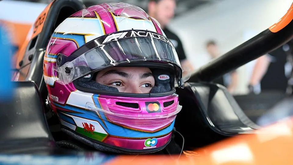 A close up shot of Ella Lloyd's helmet, which is white at the top, with a visor and the Wales flag on the bottom left of the helmet.