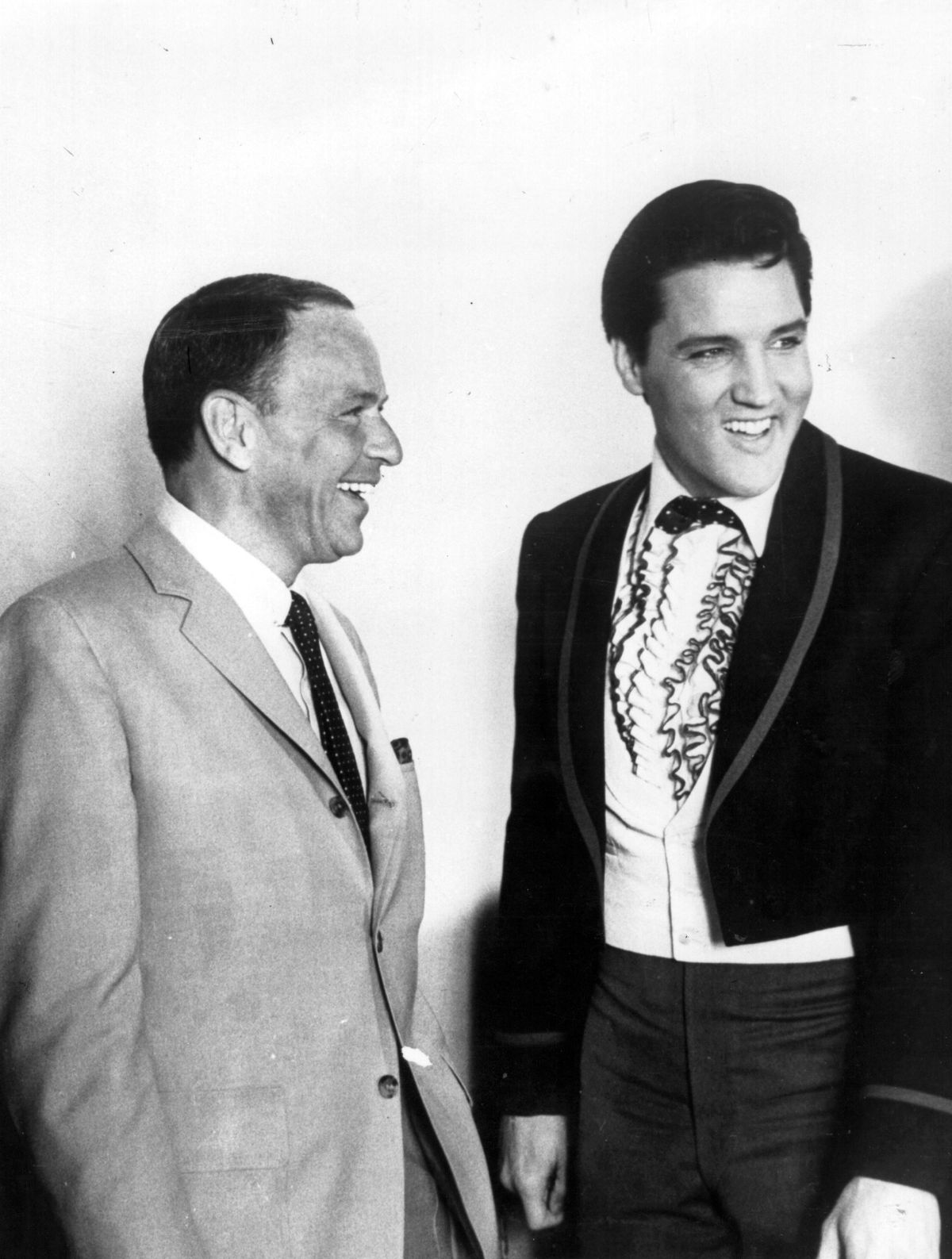 18th June 1965: The most popular male voices in the USA, singers Frank Sinatra (1915 - 1998), left, and Elvis Presley (1935 - 1977) share a joke together in Hollywood