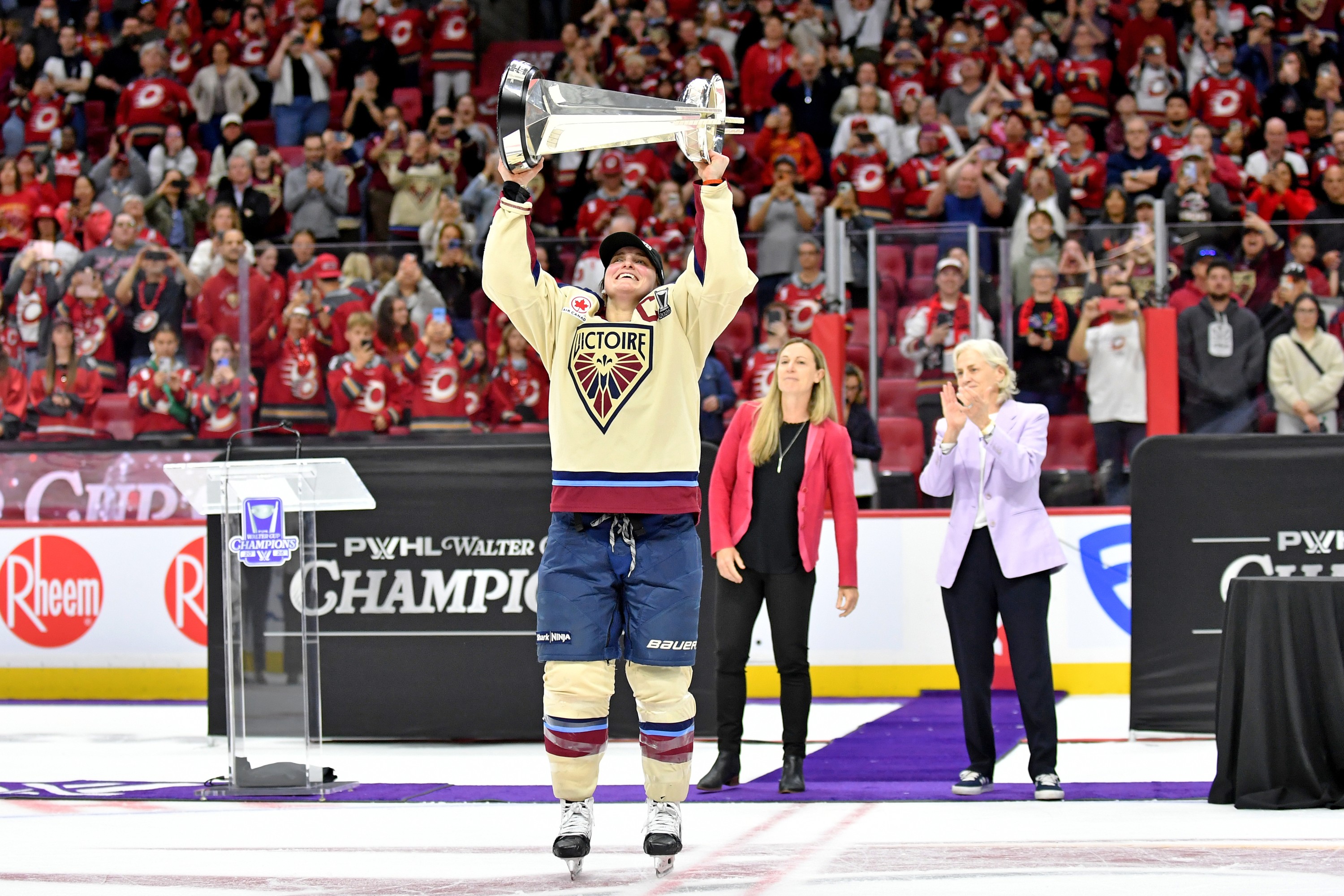 Marie-Philip Poulin hoists the Walter Cup trophy on the ice.