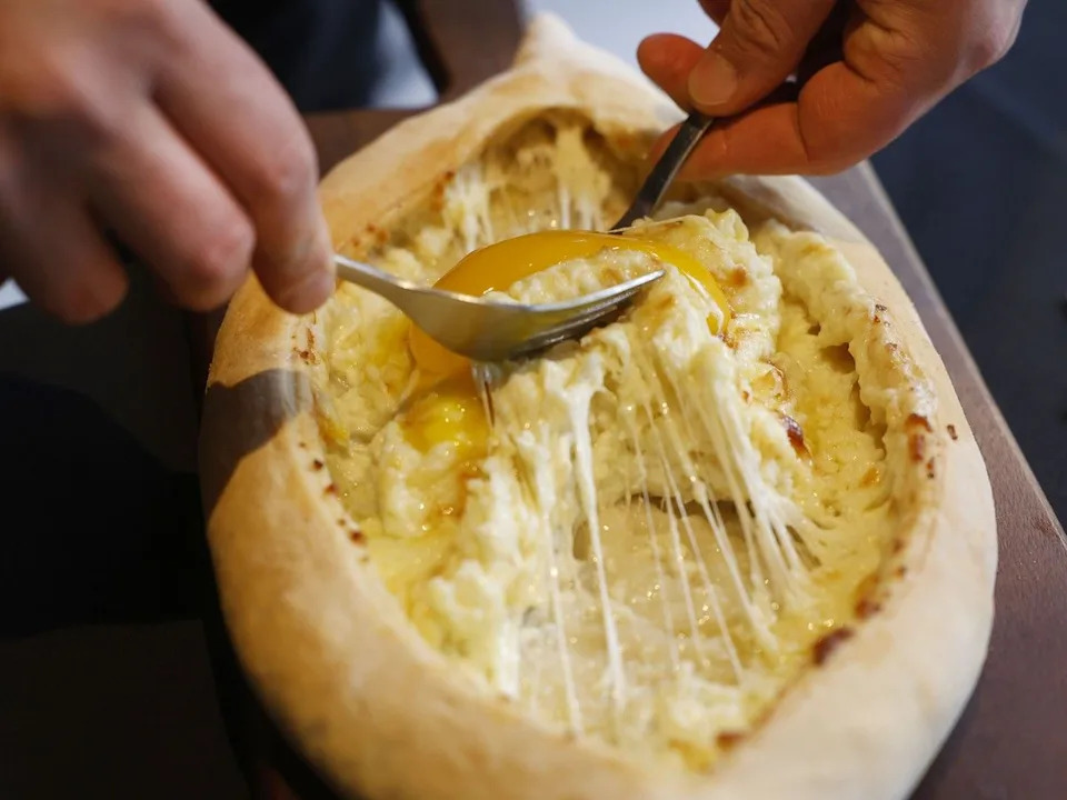 At Yan’s Restaurant on Murray Street, Khachapuri, a boat-shaped bread, has its filling of cheese and egg tossed table-side.