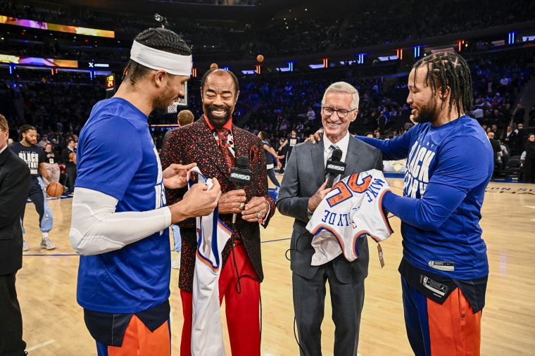 Josh Hart and Jalen Brunson of the New York Knicks congratulate Walt Frazier and Mike Breen.