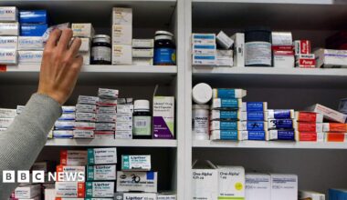 A pharmacist stocking shelves.