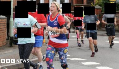 Helen Green is pictured during a race wearing brightly-coloured sports gear and a running number. She is surrounded on a street by other runners, whose identities have been concealed.