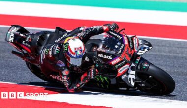 Marco Bezzecchi leans low to his right as he takes a corner
