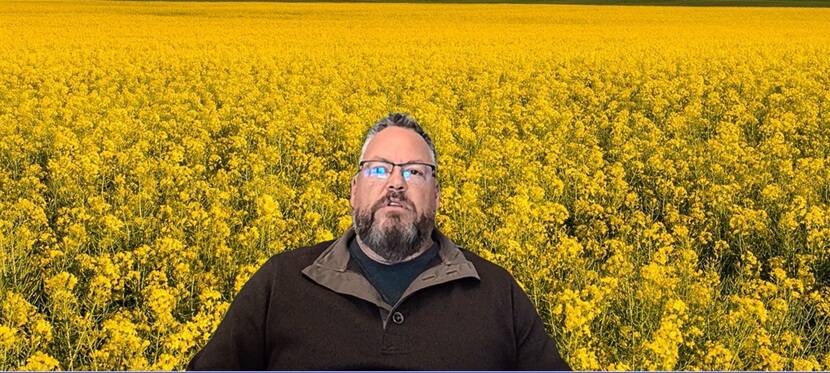 Wade Clarke, national development manager for Vive Crop Protection in Canada, in front of a projected canola background. Photo: Screen Capture/Jeff Melchior.