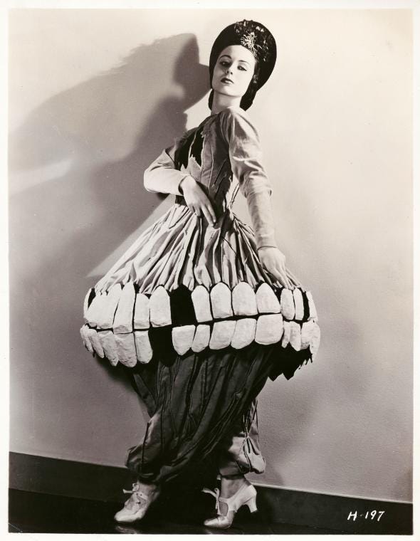 A figure wearing an unconventional dress resembling teeth.