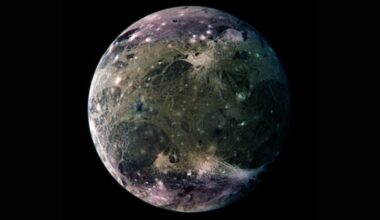 A close up of the blue and gray moon Ganymede in the darkness of space.