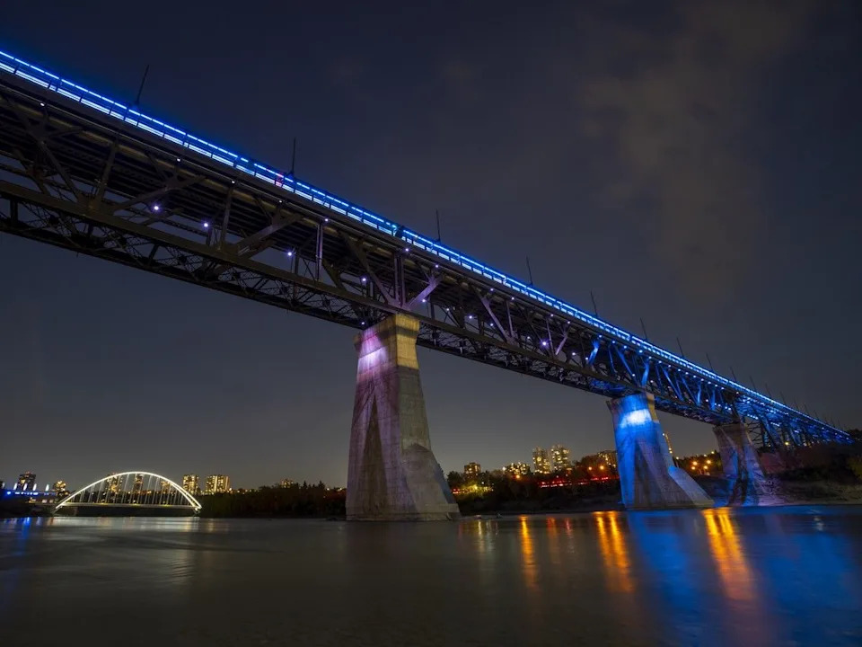 The High Level Bridge is lit up for Peace Officers and Police Memorial Day on Monday, Sept. 25, 2023, in Edmonton. The new Walterdale Bridge can be seen in the background. Greg Southam-Postmedia