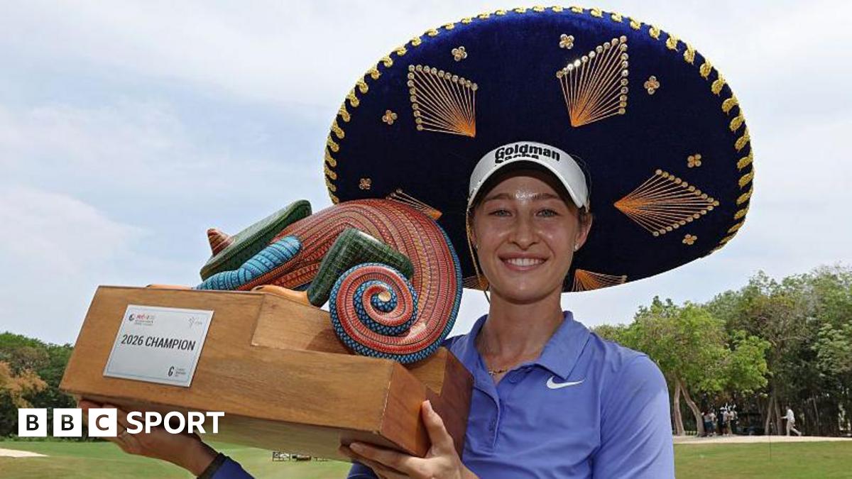 Nelly Korda celebrates winning the Riviera Maya Open in Mexico, wearing a traditional large Mexican hat and blue golf shirt, smiling, and holding a colourful trophy