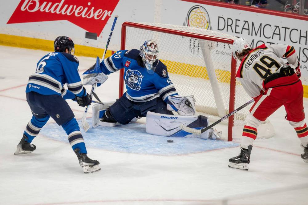BROOK JONES/FREE PRESS
Manitoba Moose goaltender Domenic Divincentiis kicks out his left pad to stop a shot by Grand Rapids Griffins centre Wojciech Stachowiak (No. 49) during first period action Saturday in Winnipeg.