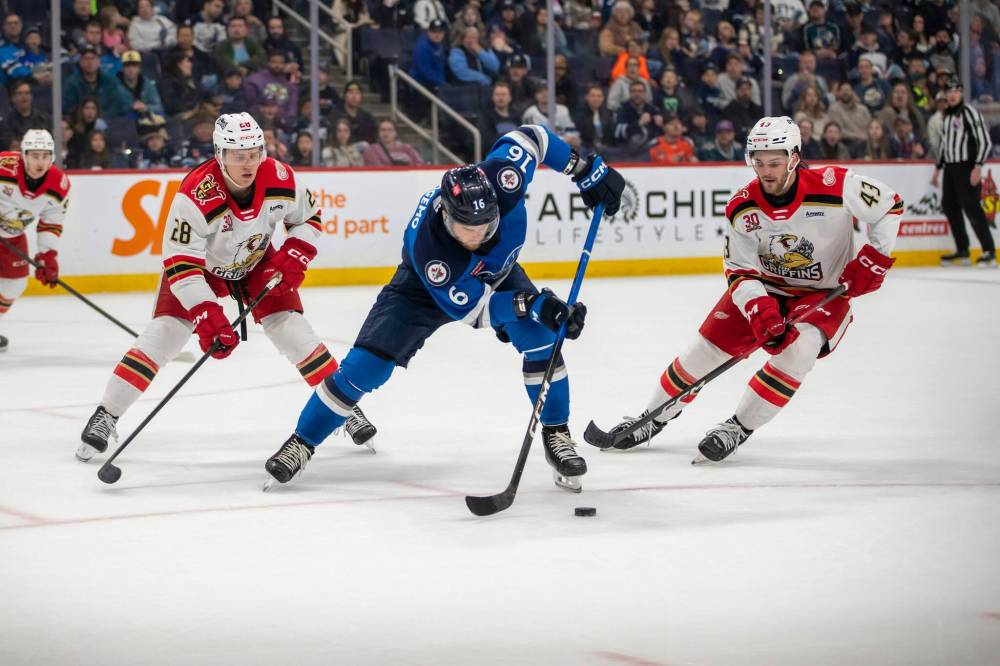 BROOK JONES/FREE PRESS
Manitoba Moose left-winger Samuel Fagemo plays the puck while Grand Rapids Griffins right-winger Michael Brandsegg-Nygård and Griffins teammate right-winger Carter Mazur (No. 43) cover him during second period action Saturday in Winnipeg.