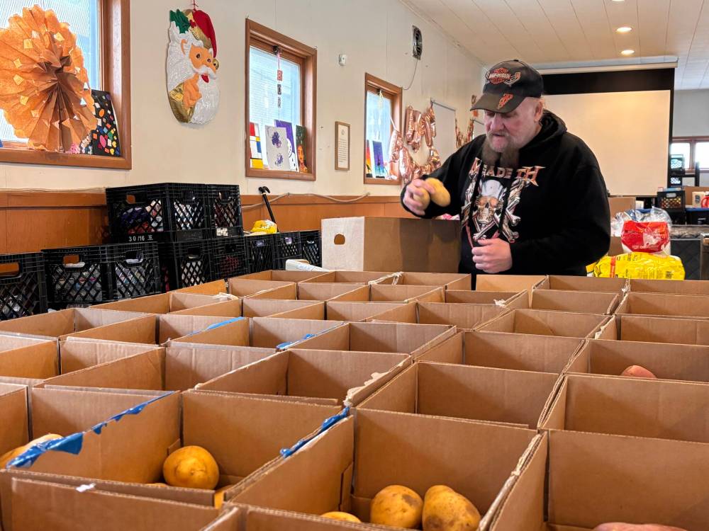 John Longhurst / Free Press
Volunteer Gerrard Lightfoot packs food boxes at St. Thomas Anglican Church.