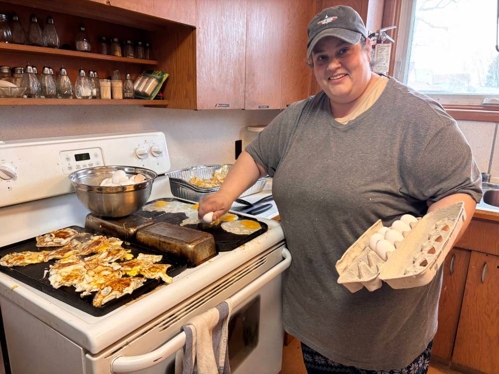 John Longhurst / Free Press
Volunteer Meredith Robinson fries eggs for meals at St. Thomas Anglican Church.