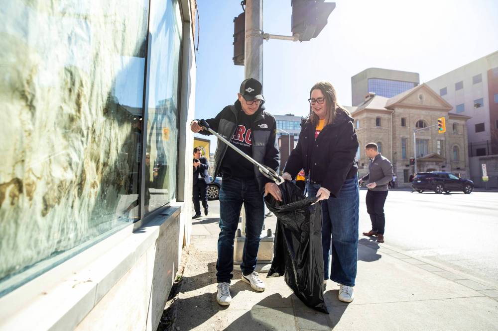 MIKAELA MACKENZIE / FREE PRESS
Downtown Winnipeg BIZ CEO Kate Fenske and Mayor Scott Gillingham take part in the spring cleanup on Thursday.