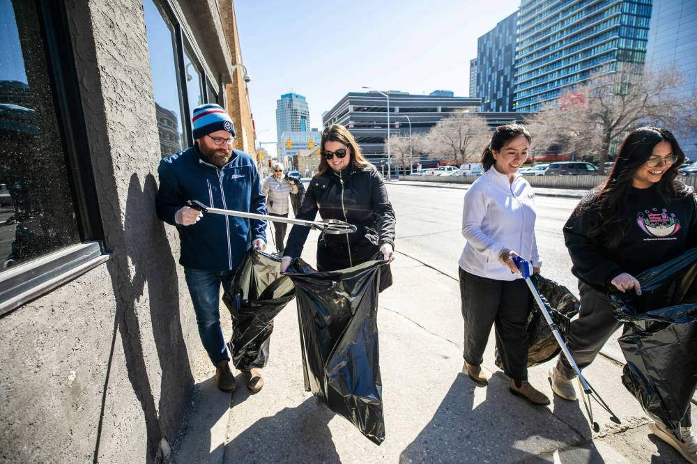 MIKAELA MACKENZIE / FREE PRESS
Paul Mailhot (left) and Kalyn Pyl take part in the spring cleanup on Thursday.