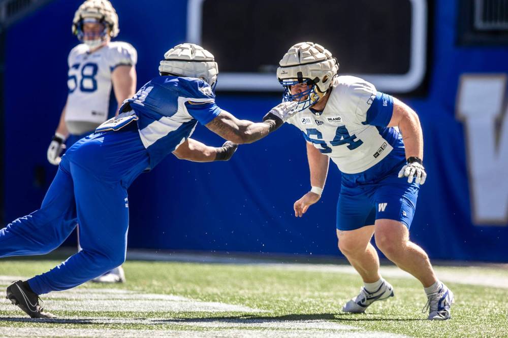 MIKAELA MACKENZIE / FREE PRESS
Tyler Elsbury (right) runs drills at the Winnipeg Blue Bombers rookie camp Friday. The offensive linesman joined the Bombers midway through last year’s training camp and the club kept him around, but his season was cut short when he returned to Iowa City in July to deal with a personal matter.
