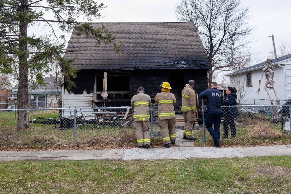 MIKE DEAL / FREE PRESS
Fire investigators examine the scene at Alvin Flett’s Lock Street home early Tuesday.