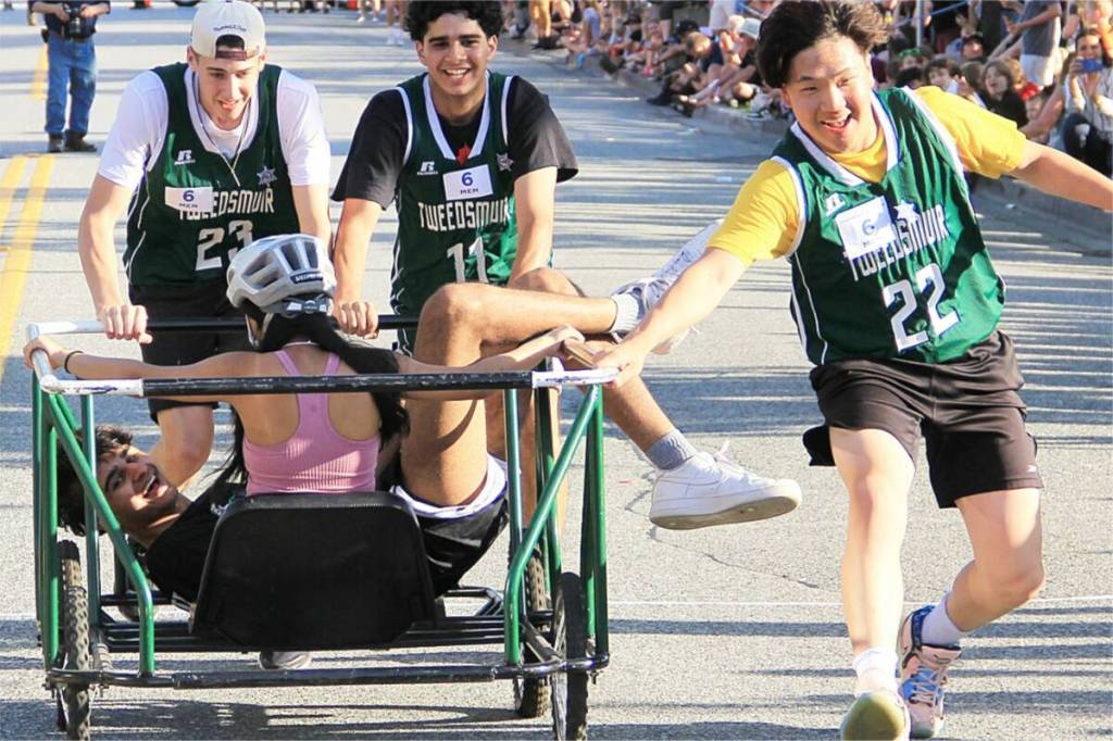 A runner on the Lord Tweedsmuir racing team ended up on top of the squad&rsquo;s bed-race rider in 2023 after he performed a &ldquo;miraculous endo.&rdquo; The runner tripped and miraculously bounced up and flipped up into the car, thus avoiding being run over by the bed. (Photo: Malin Jordan)