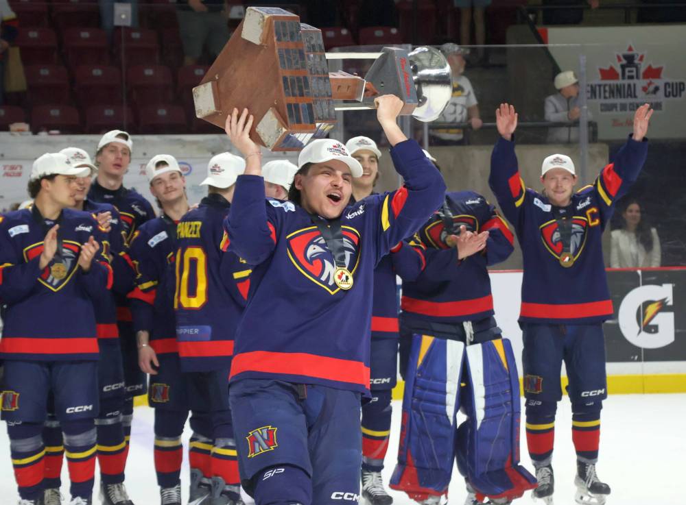Marlen Edwards lifts the Centennial Cup into the air after helping the Niverville Nighthawks to a national championship. (Cassidy Dankochik / The Carillon)