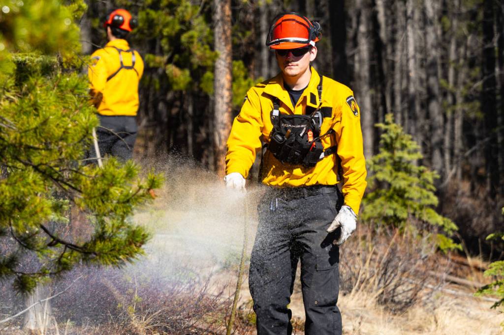 Firefighters wet down foliage ahead of a prescribed burn near Robert Service way in Whitehorse on Wednesday, May 13, 2026. (Photo by Noah Korver/Yukon News)