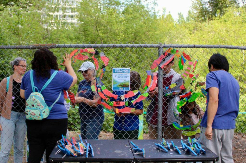 Attendees installed 300 painted fish in the Stream of Dreams mural along the detention pond fence. (Salmon Habitat Restoration Program/ Contributed to Surrey Now-Leader)