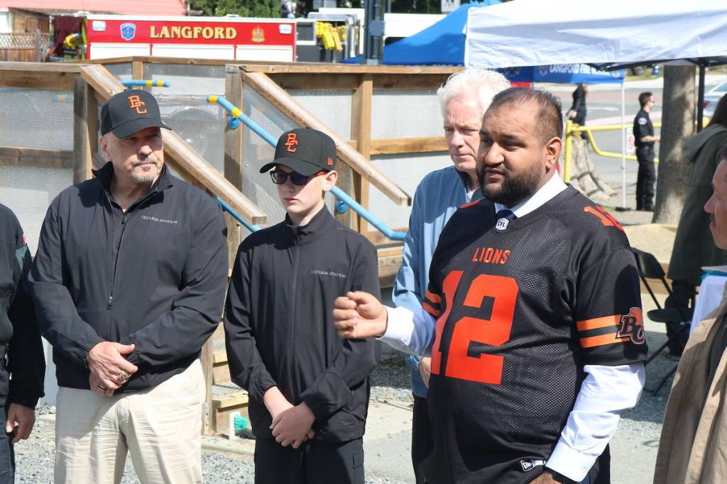 Minister of Forests Ravi Parmar speaks at the BC Lions announcement May 30, with Lions senior vice-president of business George Chayka, and Coulson Group CEO Wayne Coulson with his grandson Baron. (Ben Fenlon/Goldstream Gazette)