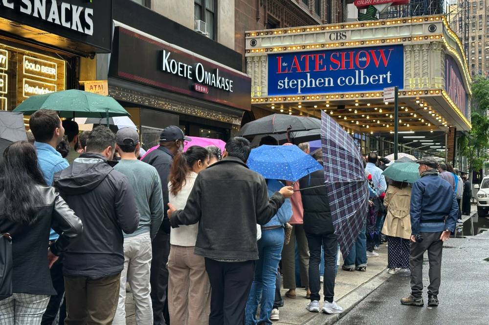 Fans line up in the rain outside the Ed Sullivan Theater in New York on Thursday, ahead of the final episode of “The Late Show with Stephen Colbert.” (Ted Shaffrey / The Associated Press files)