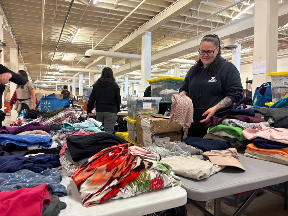 NICOLE BUFFIE/FREE PRESS
Tara, a volunteer with Linking Hope, sorts women’s clothes Saturday afternoon at the non-profit organization’s new warehouse at 323 Edwin St.