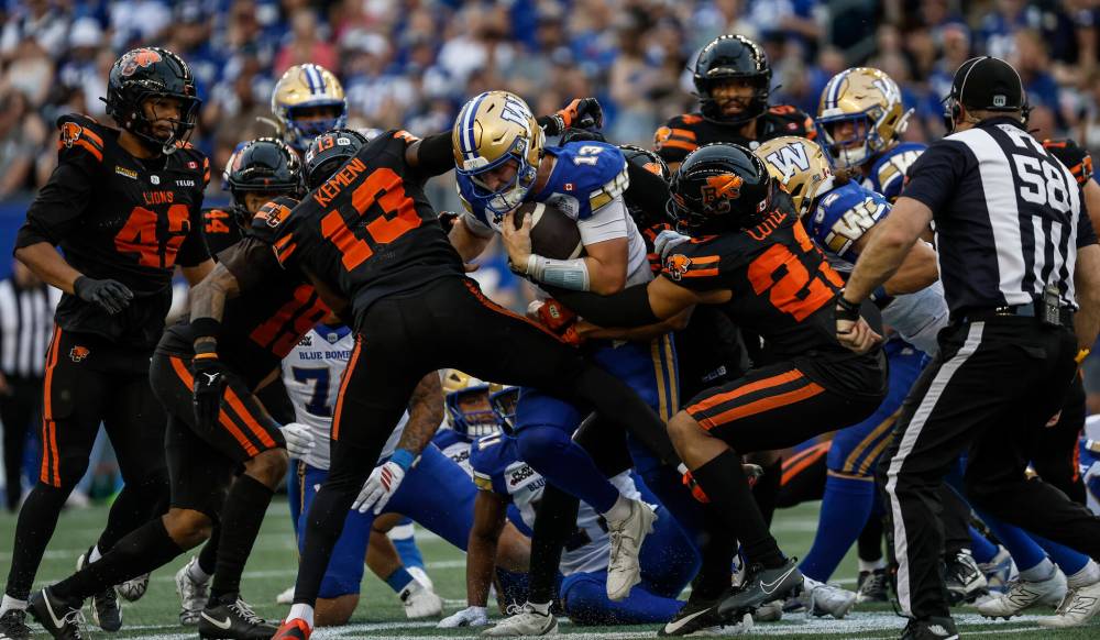 THE CANADIAN PRESS/JOHN WOODS
Winnipeg Blue Bombers quarterback Taylor Elgersma (centre) gets sacked by Tyler Coyle (23) amid a pride of B.C. Lions during first half CFL pre-season football action in Winnipeg on Friday.