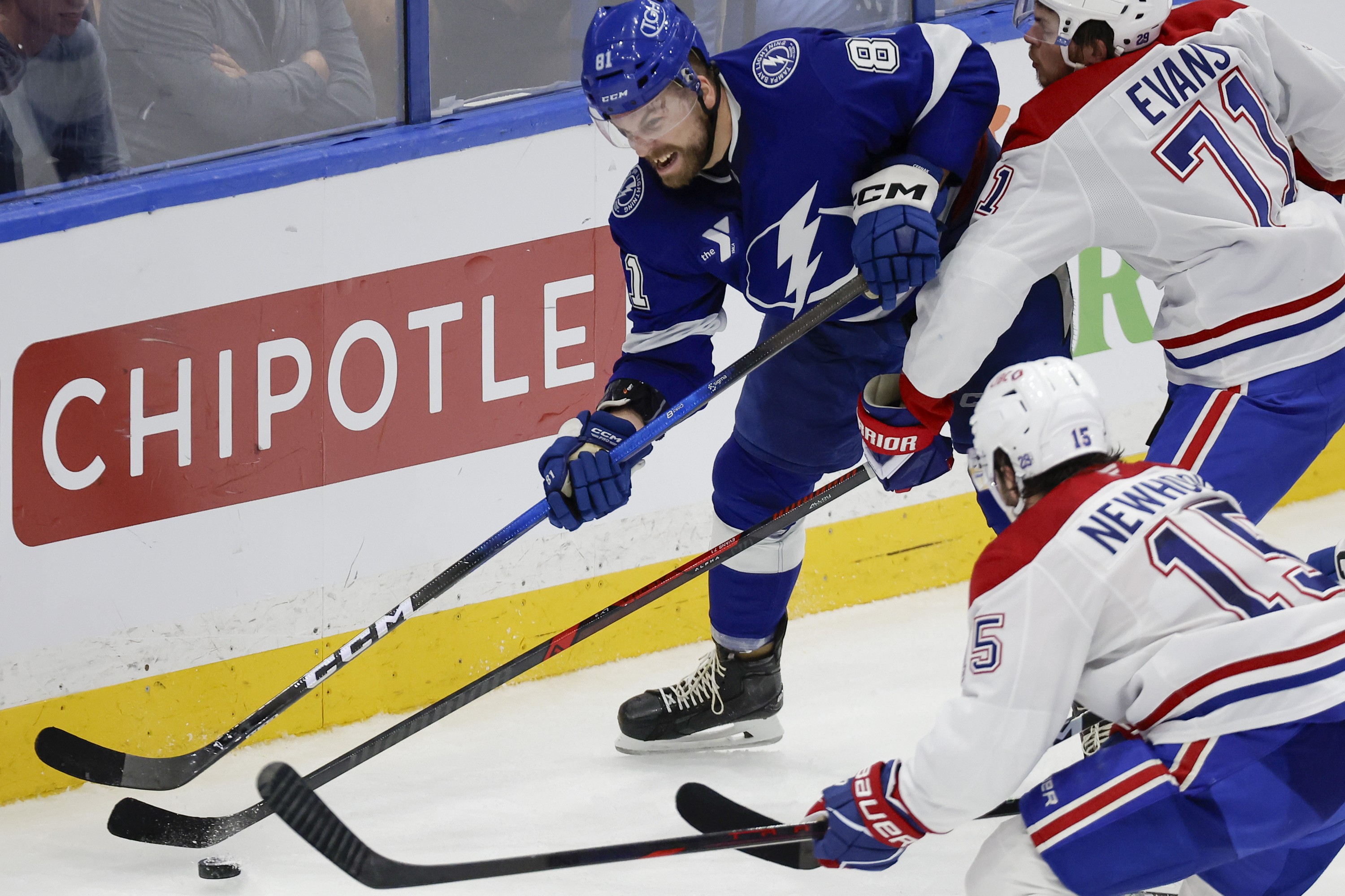 Tampa Bay Lightning defenceman Erik Cernak clears the puck from behind the goal line as Montreal Canadiens centre Jake Evans and centre Alex Newhook apply pressure