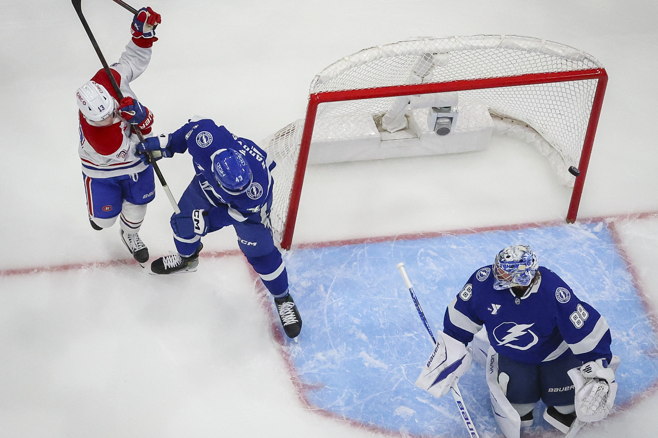 Montreal Canadiens right wing Cole Caufield along with Tampa Bay Lightning defenceman Darren Raddysh and Tampa Bay Lightning goaltender Andrei Vasilevskiy watch as the puck dribbles past the net