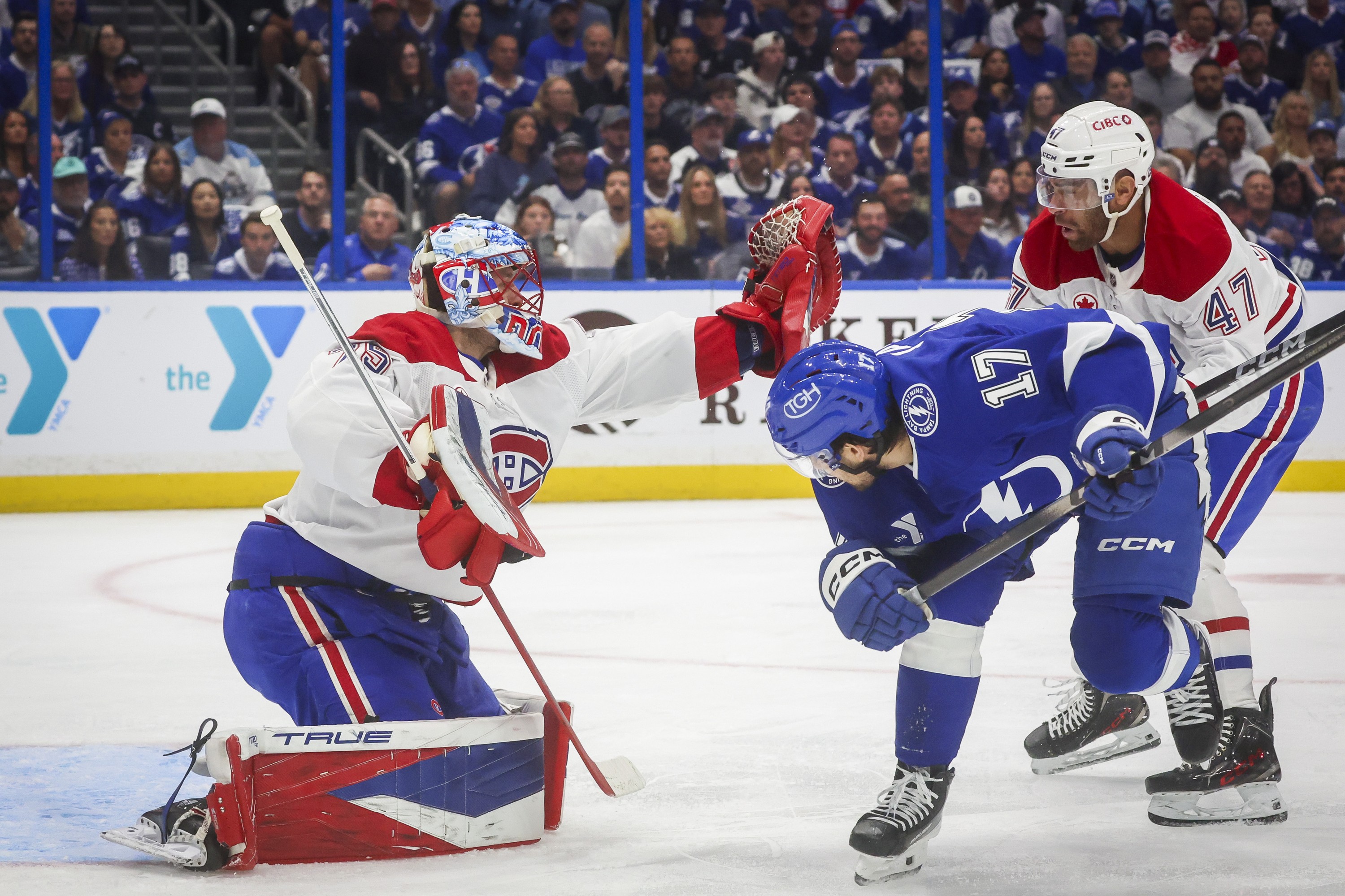 Montreal Canadiens goaltender Jakub Dobes reaches for the puck as Canadiens defenceman Jayden Struble knocks Tampa Bay Lightning centre Dominic James