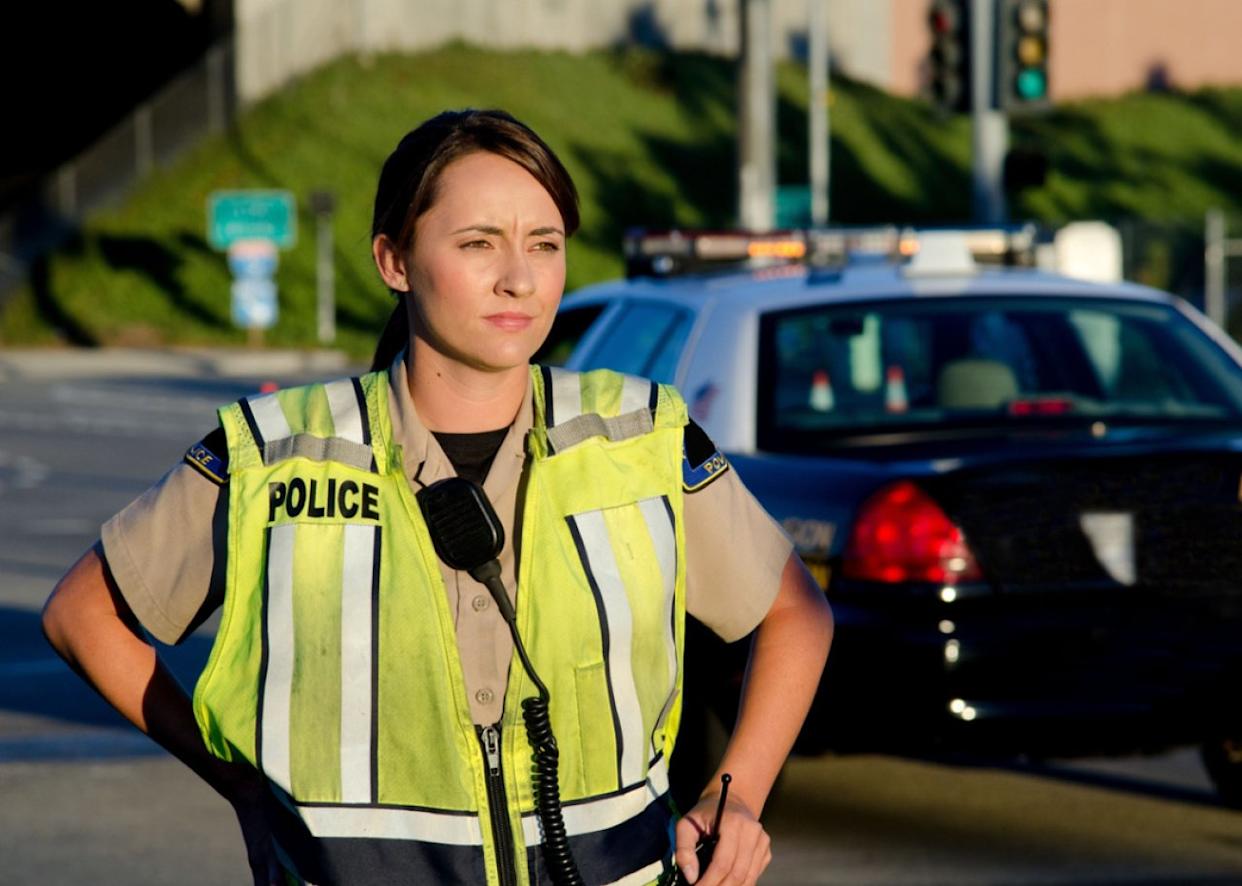 Woman police officer surveys area during a shift. - 