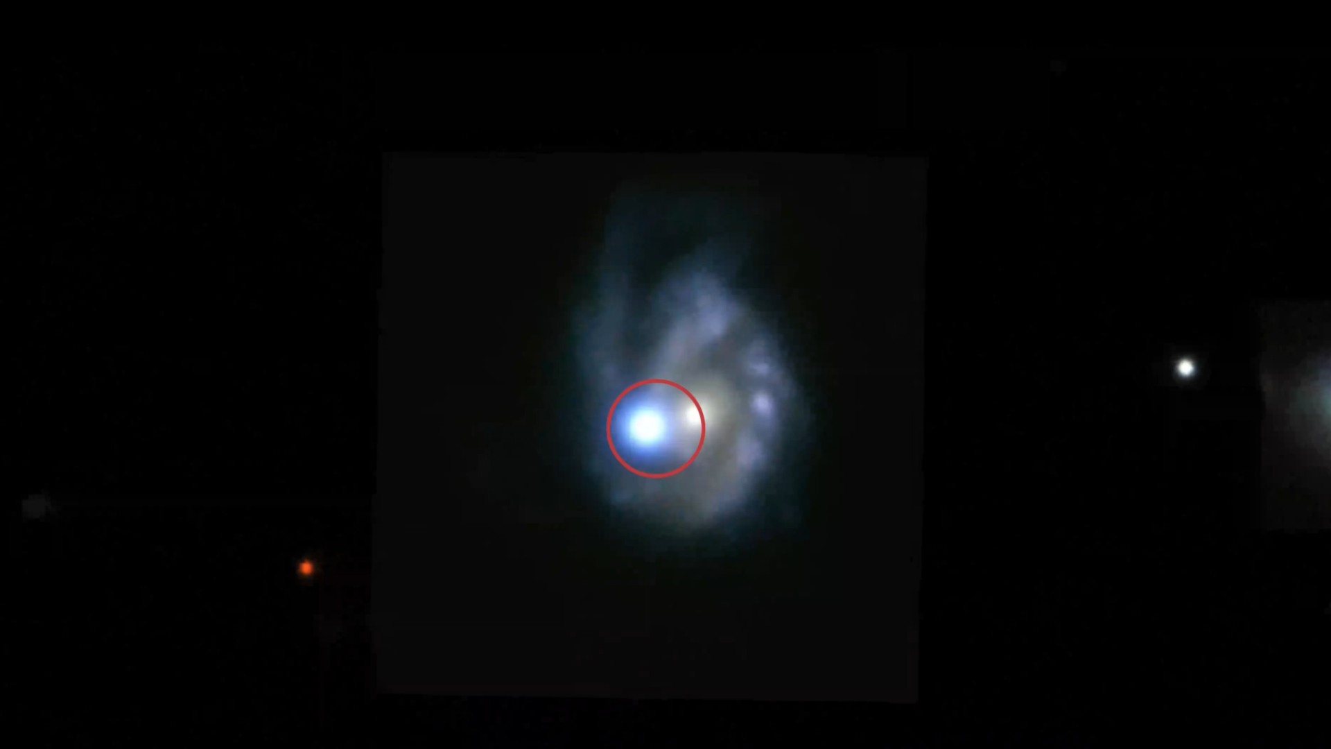 A view of a spiral galaxy with a bright spot toward the left.