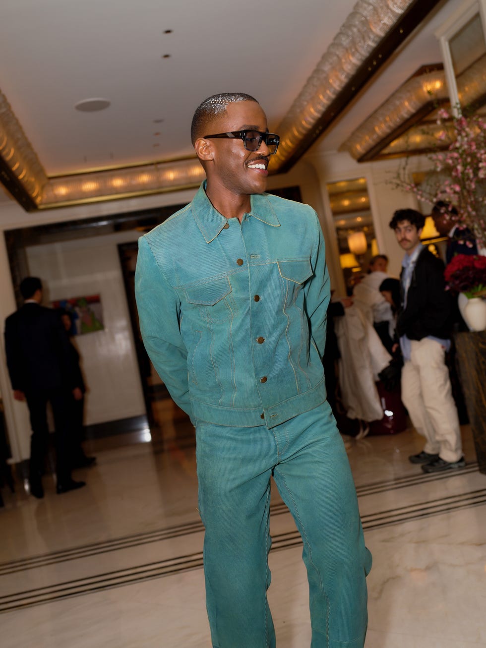 A person wearing a teal outfit in an indoor setting.