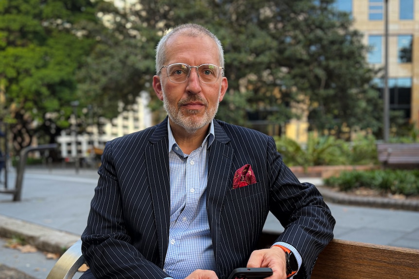 A man with glasses and a striped suit.