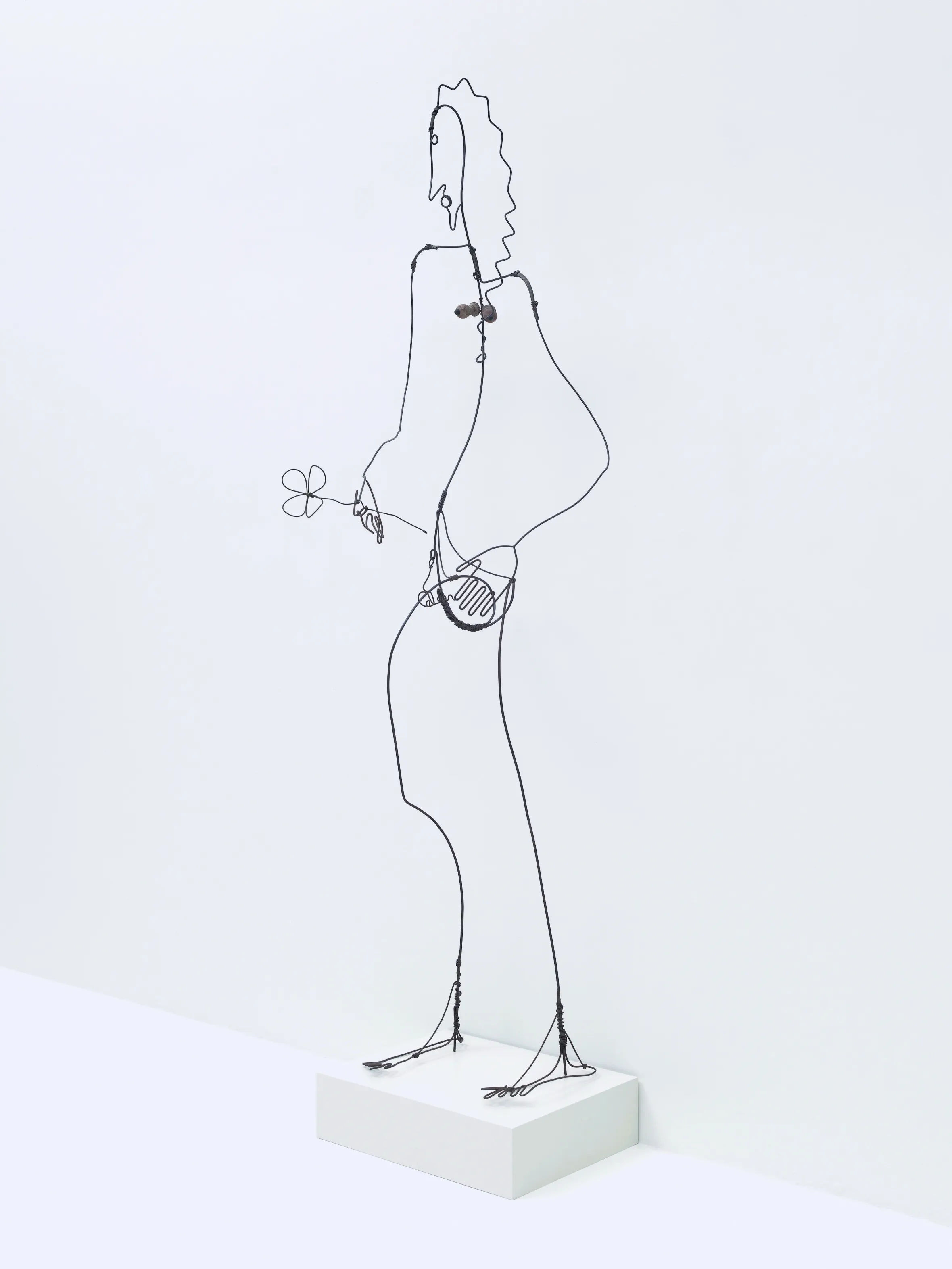 Wire sculpture of a woman holding a flower.