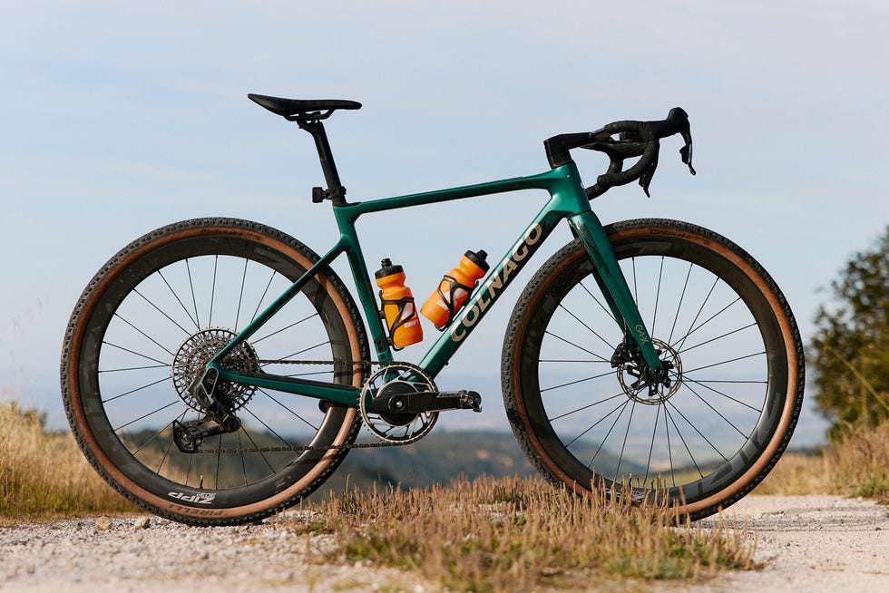 A gravel bike positioned on a dirt path with water bottles attached. A gravel bike positioned on a dirt path with water bottles attached.
