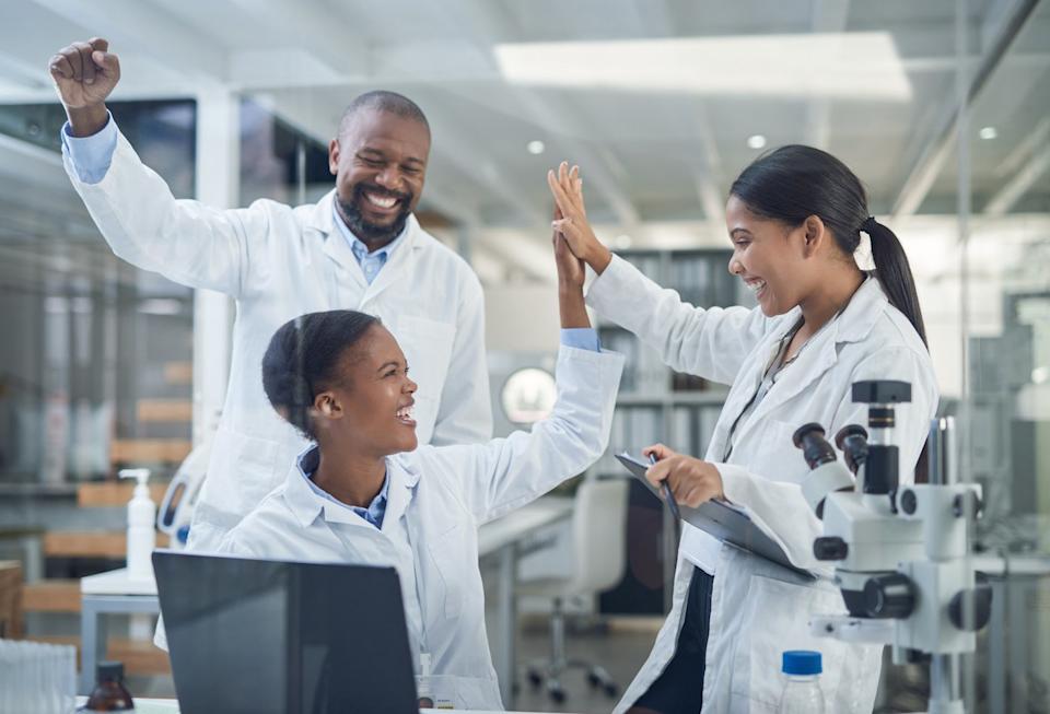 Researchers in a lab celebrate.