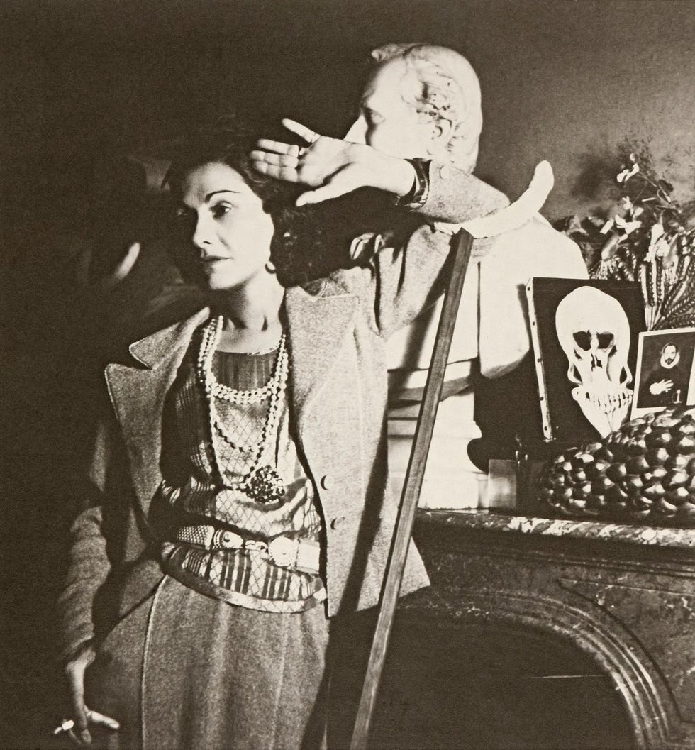 A woman posing with a hand gesture near decorative objects.