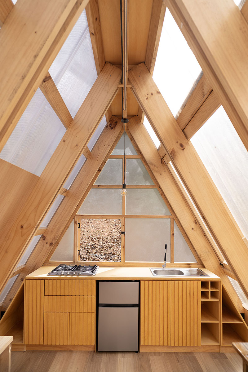 translucent polycarbonate skin envelopes triangular shelter elevated on stilts in ecuador - 7
