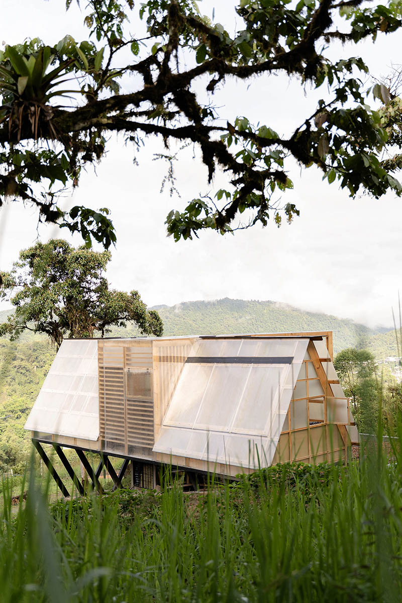 translucent polycarbonate skin envelopes triangular shelter elevated on stilts in ecuador - 3